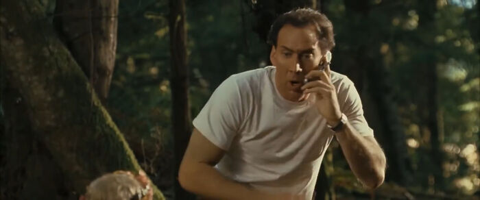 Man in a white shirt in a forest scene from one of the worst-best movies that people actually enjoy.