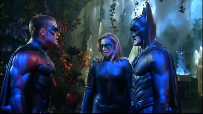 Three characters in superhero costumes standing in a misty, dimly lit forest scene from worst-best movies people enjoy.