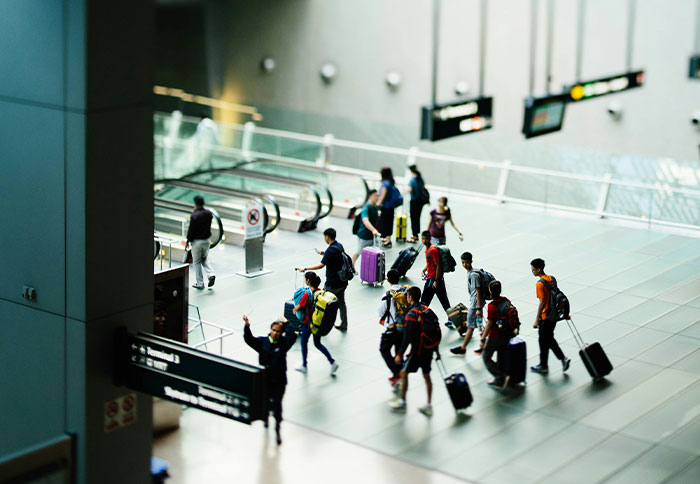 Group of travelers with luggage walking through a modern airport terminal, reflecting moments of instinct and decision-making.