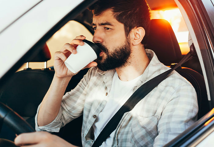 Man drinking coffee in car, illustrating moments when people were thankful they trusted their instincts.