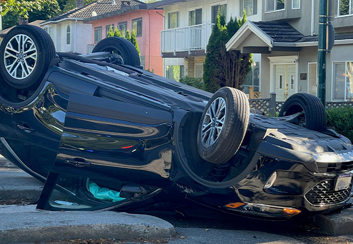 Overturned black car on a residential street highlighting moments when people were thankful they trusted their instincts.