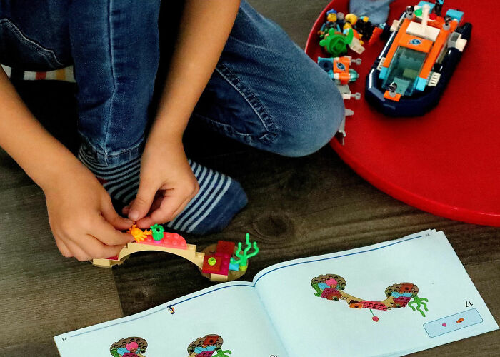 Child playing with building blocks and toys on the floor, highlighting wildest rules people grew up with memories.
