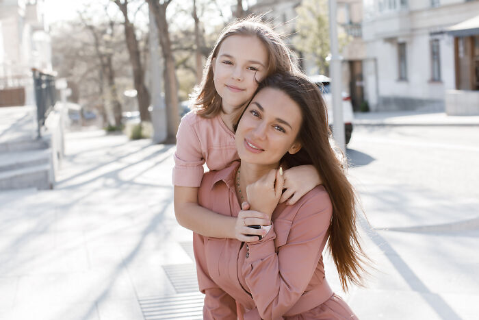 Young woman and girl embracing outdoors, symbolizing family bonds amid darkest family secrets revealed.