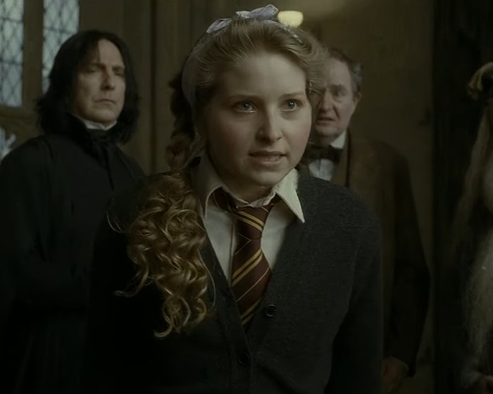 Harry Potter star with curly hair in Hogwarts uniform during intense scene with Severus Snape and others.