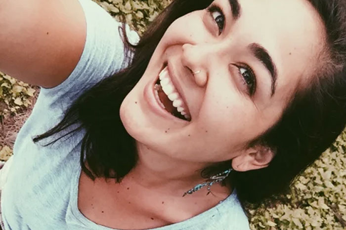 Young woman smiling outdoors, capturing a bright moment before going missing as part of chilling messages.