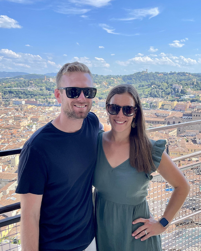 Couple wearing sunglasses posing with cityscape behind, related to hiker’s tragic last text on mountain at 13,000ft. Couple wearing sunglasses posing with cityscape behind, related to hiker’s tragic last text on mountain at 13,000ft.