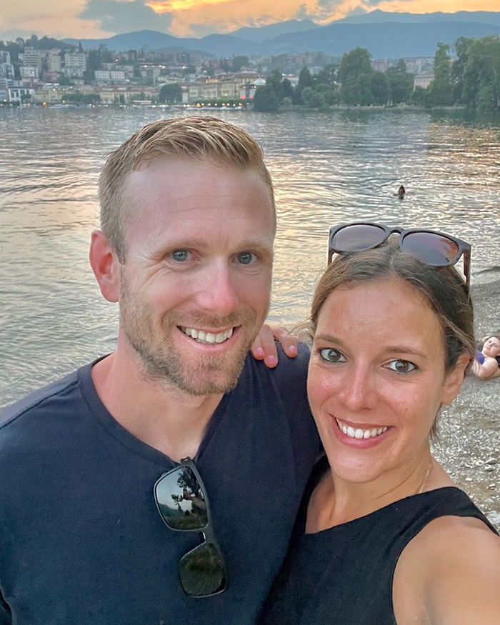 Smiling couple posing by lake shore at sunset, representing hiker’s tragic last text to wife found lifeless on high mountain. Smiling couple posing by lake shore at sunset, representing hiker’s tragic last text to wife found lifeless on high mountain.