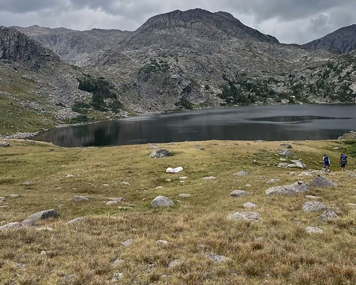Mountain landscape at 13,000ft with hikers near a lake, related to hiker’s tragic last text reveal. Mountain landscape at 13,000ft with hikers near a lake, related to hiker’s tragic last text reveal.