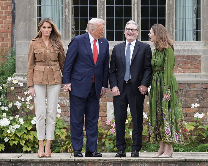Melania Trump and others standing outdoors in formal attire, showcasing wardrobe choices during UK state visit. Melania Trump and others standing outdoors in formal attire, showcasing wardrobe choices during UK state visit.