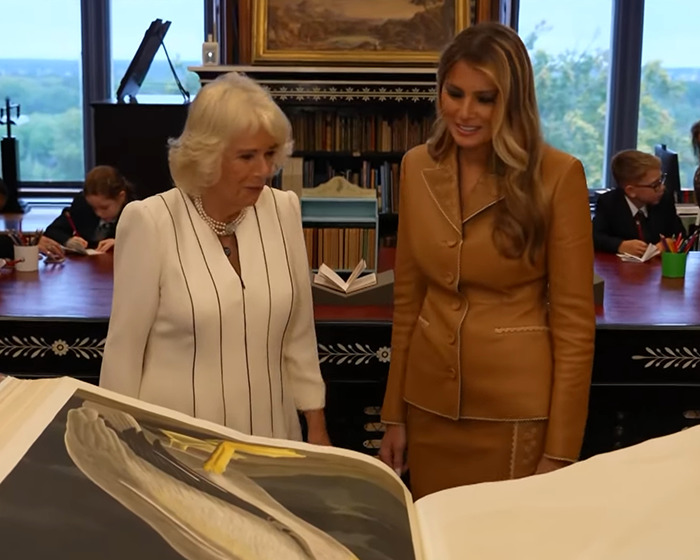 Melania Trump and Camilla exploring a large book indoors, highlighting wardrobe choices during UK state visit. Melania Trump and Camilla exploring a large book indoors, highlighting wardrobe choices during UK state visit.