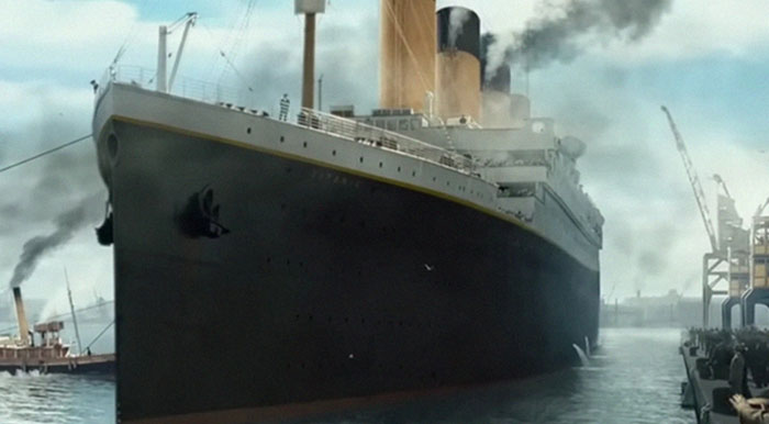 Large historic passenger ship docked at port with smoke rising from chimneys in iconic bruh moments in history