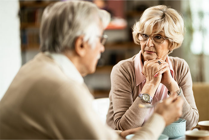 Older woman looking concerned during a serious conversation with an elderly man about a life-threatening allergy situation. Older woman looking concerned during a serious conversation with an elderly man about a life-threatening allergy situation.