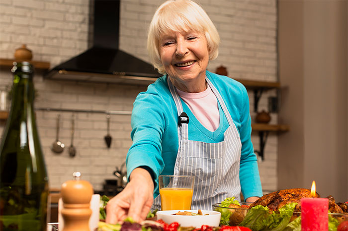 Elderly woman preparing food in kitchen, illustrating woman goes no-contact with her MIL after allergy test conflict. Elderly woman preparing food in kitchen, illustrating woman goes no-contact with her MIL after allergy test conflict.