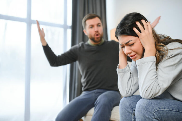 Couple arguing at home with woman distressed, illustrating signs of a possible spouse causing regret in relationships.