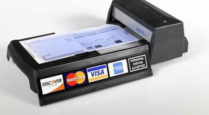 Check scanner device processing a personal check, nostalgic item reminding people of old age and past financial methods.