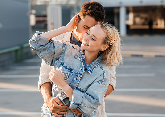 Couple embracing outdoors, highlighting relationship intimacy and boundaries in a casual urban setting.