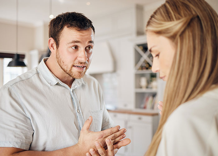 Husband and wife having serious conversation about changing intimacy boundaries in a modern kitchen setting.