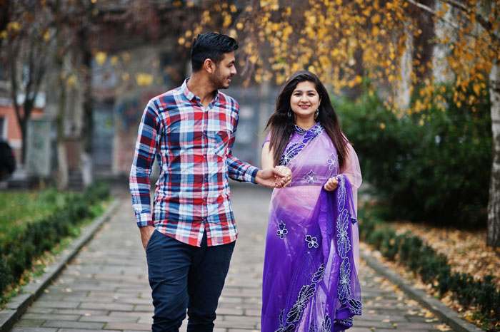 Couple holding hands walking outdoors in autumn, representing husband parents native language connection and culture.