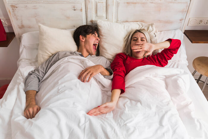Couple in bed showing funny reactions, illustrating women sharing reasons why they got the ick from a guy in relationships.
