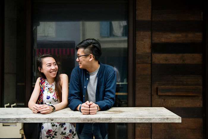 Young woman and man smiling and chatting by a table, illustrating reasons women got the ick from a guy.
