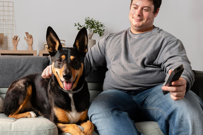 Man sitting on a couch with a dog, illustrating reasons why women got the ick from a guy in casual home setting.