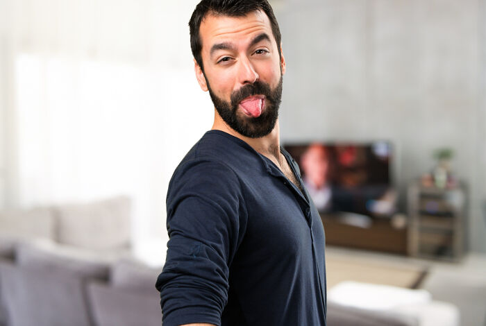 Man making a funny face with his tongue out, illustrating reasons why women get the ick from a guy.