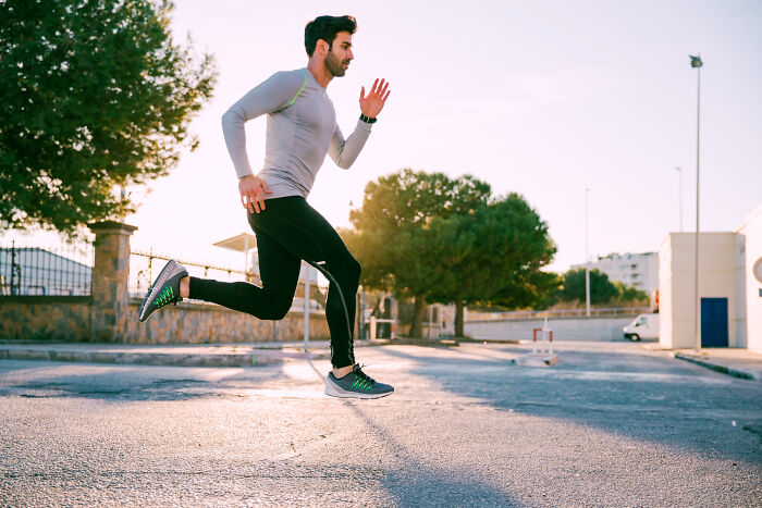 Athletic man running outdoors in casual sportswear, illustrating a dynamic moment related to reasons women get the ick from a guy.