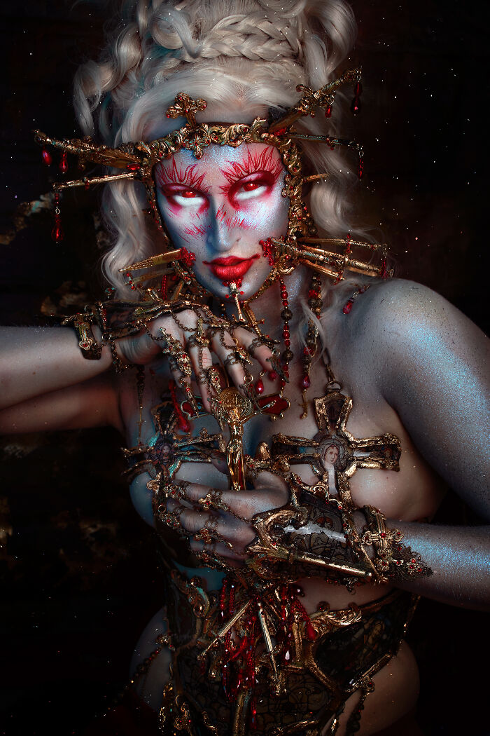 Person transformed into a haunting Halloween character with elaborate makeup and ornate golden accessories against a dark background.