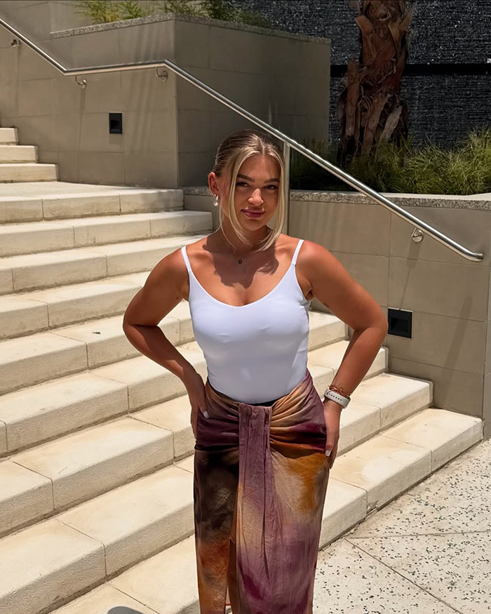 Young woman posing outdoors on stairs, wearing a white top and colorful skirt, related to viral engagement post topics. Young woman posing outdoors on stairs, wearing a white top and colorful skirt, related to viral engagement post topics.