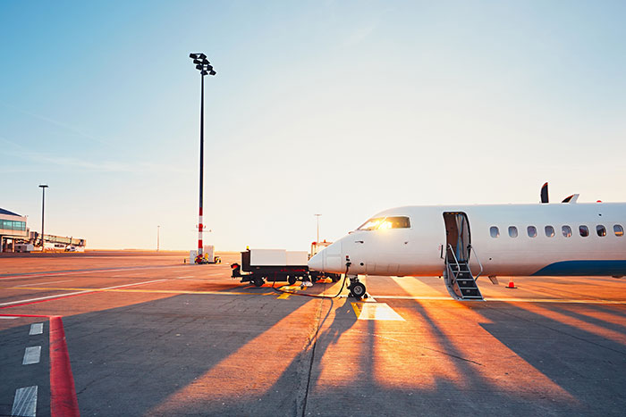 Private jet parked on airport tarmac at sunset, highlighting fascinating knowledge about travel and aviation facts.