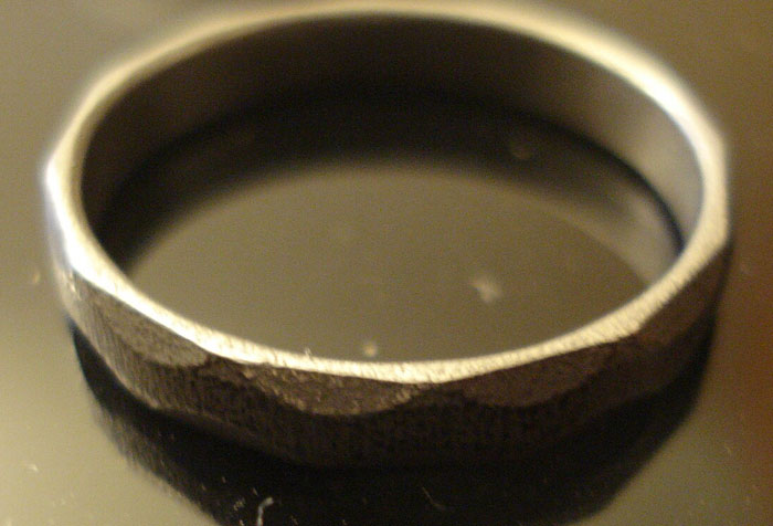 Close-up of a unique textured ring on a reflective surface illustrating fascinating knowledge from daily useless facts.