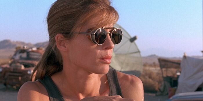 Female character in a movie wearing sunglasses in a desert setting, representing well-written female characters breaking stereotypes.