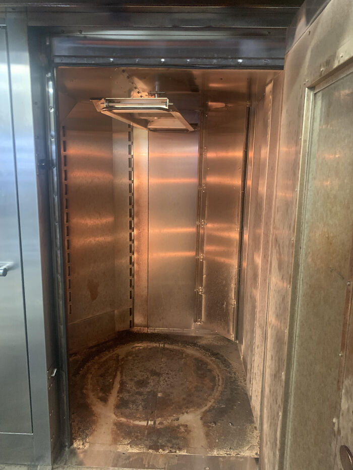 Industrial metal oven interior showing worn and dirty surfaces from jobs that should pay more based on worker photos