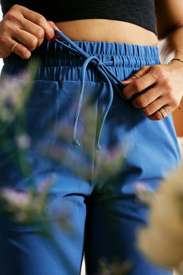 Close-up of hands tying the drawstring on blue pants, showing everyday things that humble fully grown adults.