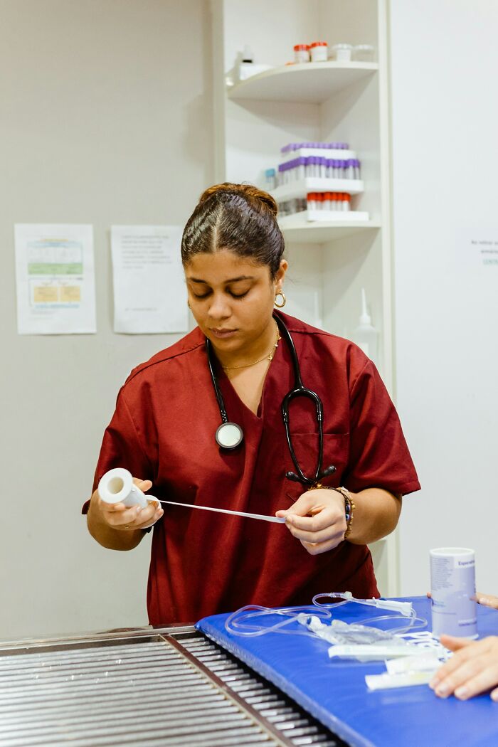 Healthcare professional preparing medical supplies, highlighting care and attention in a clinical environment with focused expression.