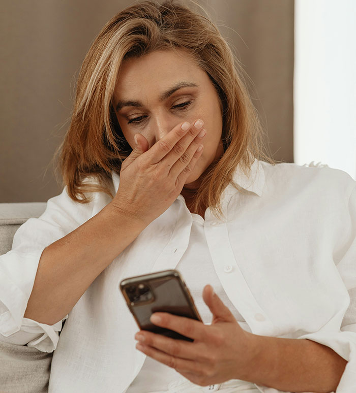 Woman upset and emotional while looking at phone, reflecting feelings of a woman remarry upset about a cheater ex. Woman upset and emotional while looking at phone, reflecting feelings of a woman remarry upset about a cheater ex.