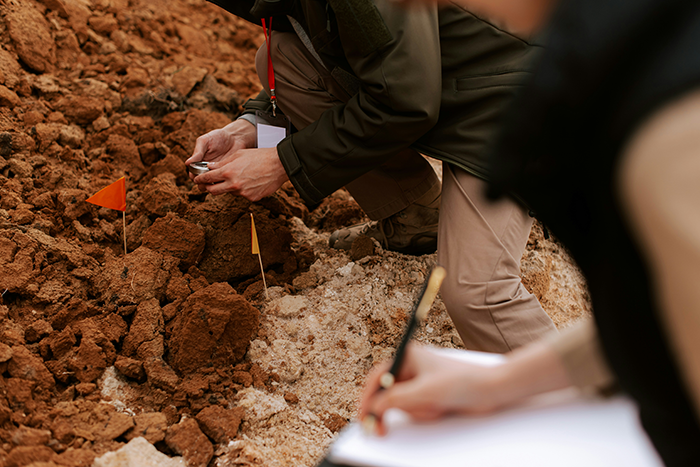 Archaeologists documenting and excavating ancient skeletons buried under an abandoned department store site.