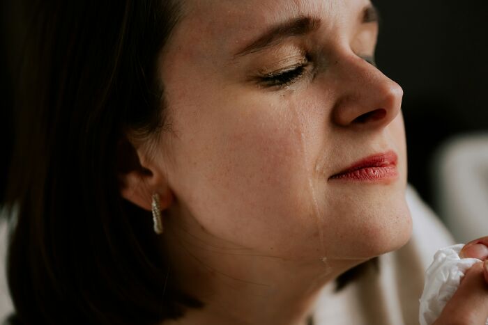 Close-up of a woman shedding a tear, reflecting the emotional impact of draining savings in one go.