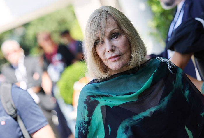 Kim Novak at Venice Film Festival wearing a green and black shawl while receiving a lifetime achievement award.