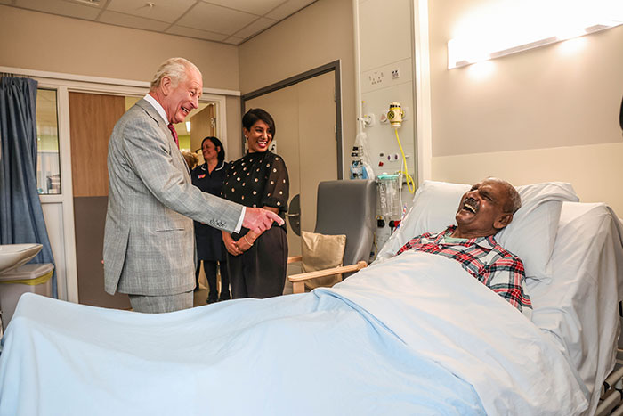 King Charles visiting a hospital patient, sharing an emotional update on his incurable cancer and health challenges.