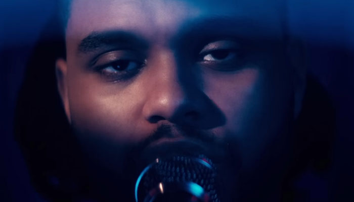 Close-up of a man singing into a microphone, illustrating people who knew celebrities before fame sharing insights.