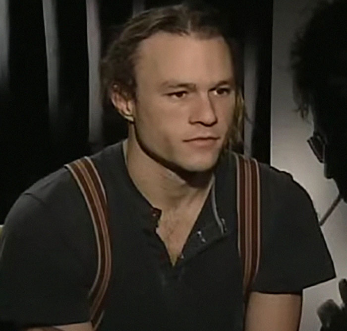 Young man with suspenders being interviewed, related to people who knew celebrities before fame revealing what they were like.