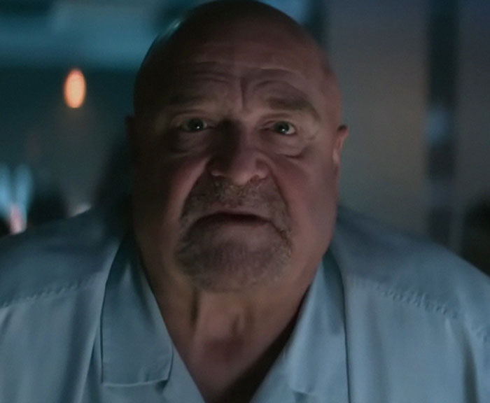 Close-up of an older man in dim light sharing memories as part of people who knew celebrities before fame.