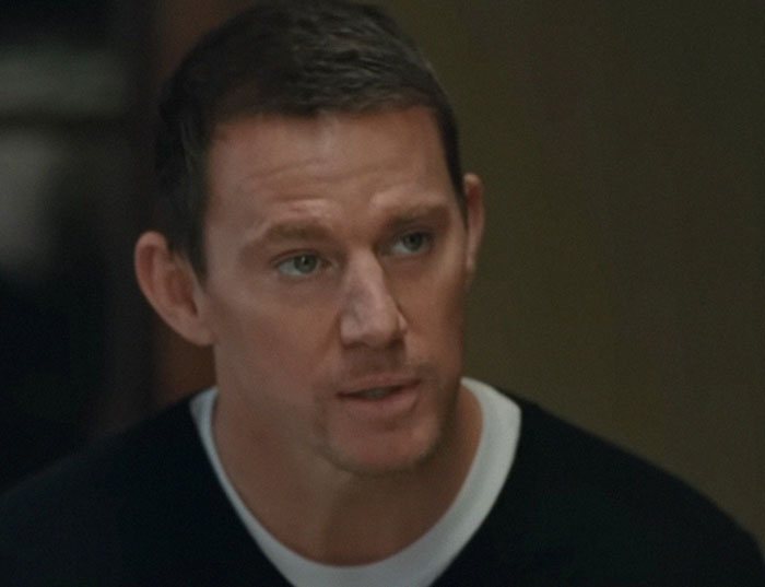 Man in a black sweater sharing stories from people who knew celebrities before fame in a casual indoor setting.