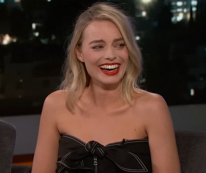 Actress sharing stories about celebrities before fame, smiling and engaging in a lively TV interview setting.