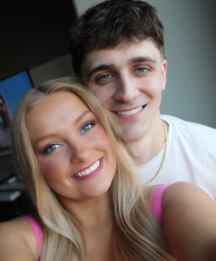 Young couple smiling together in a casual setting, related to social media posts about motherhood and hidden baby body story.