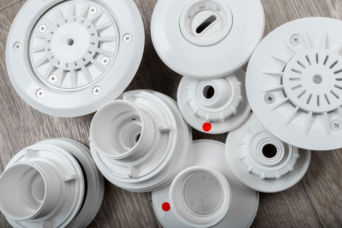 Several white smoke detectors laid out on a wooden surface relating to landlord malicious compliance drama.