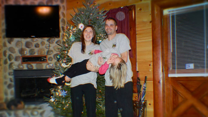 Family posing by a decorated Christmas tree in a cozy room, related to mom who anonymously sent lewd texts case. Family posing by a decorated Christmas tree in a cozy room, related to mom who anonymously sent lewd texts case.