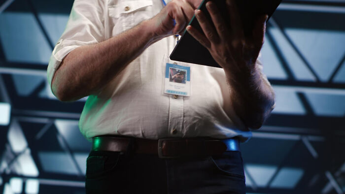 Police officer wearing badge and white shirt writing notes on a tablet about dumb ways people incriminated themselves.