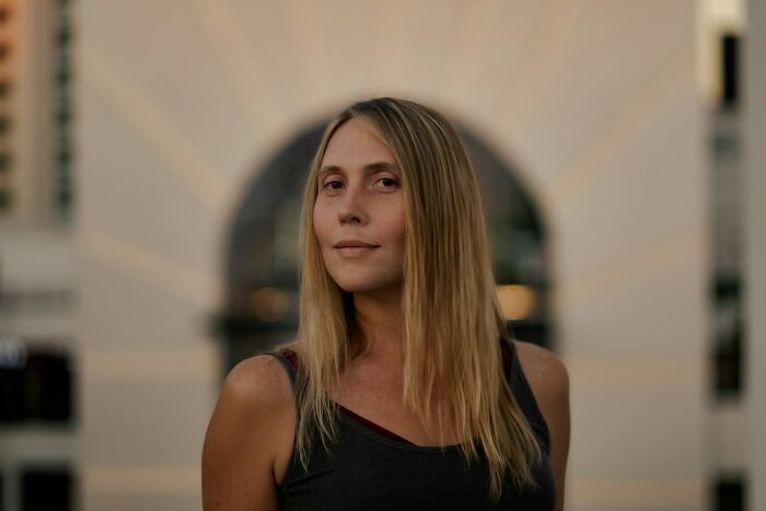 Woman with long blonde hair standing outdoors with a calm expression, representing reflections on school bullies and their lives.